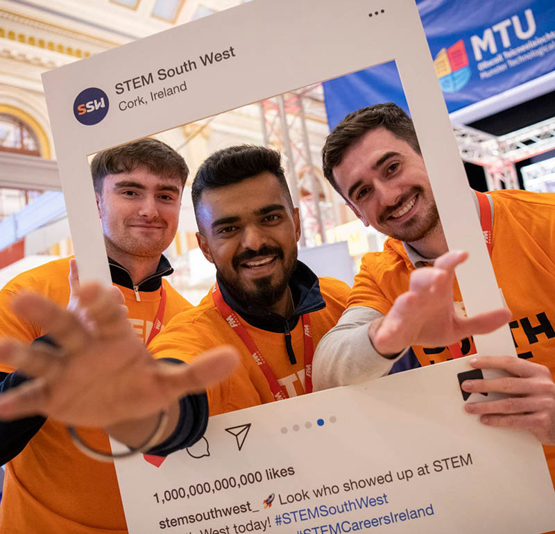 STEM South West volunteers posing with a photo frame prop at the event in Cork, Ireland.